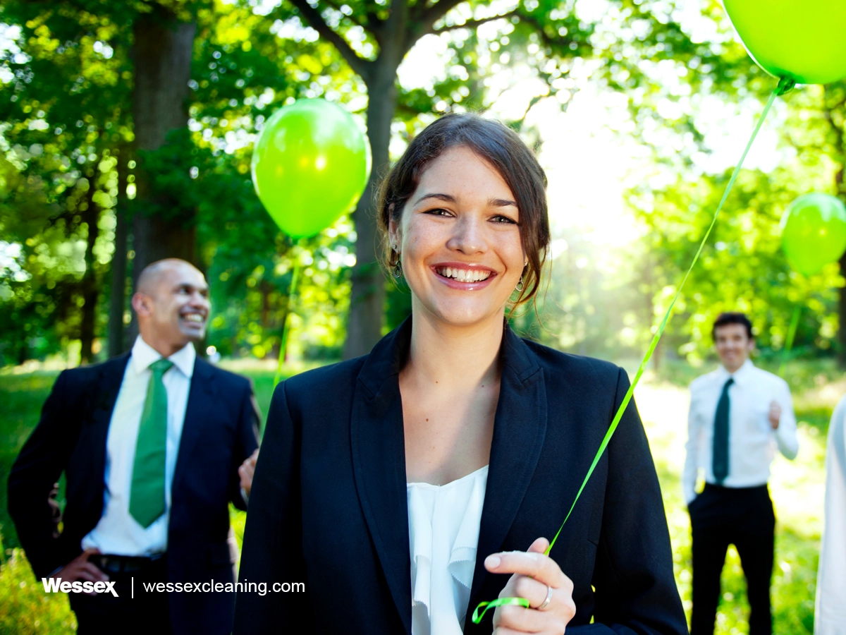 Business professionals holding green balloons, symbolizing sustainability and the benefits of the UK’s Net Zero Strategy for businesses.