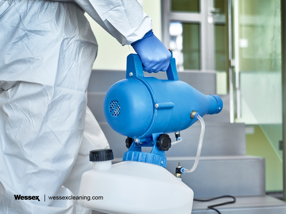 A professional cleaner disinfecting an office space with an electrostatic sprayer, ensuring thorough coverage for workplace hygiene.