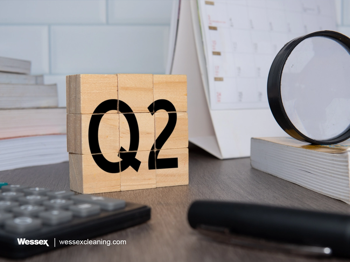 Close-up of wooden cubes with the letters Q2, symbolising mid-year maintenance in an office setting.