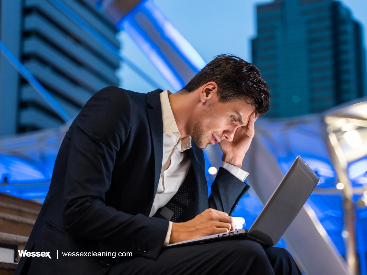 Caucasian businessman talking on a mobile phone while working in the city at night, symbolizing the need for vigilance in identifying greenwashing in business practices.