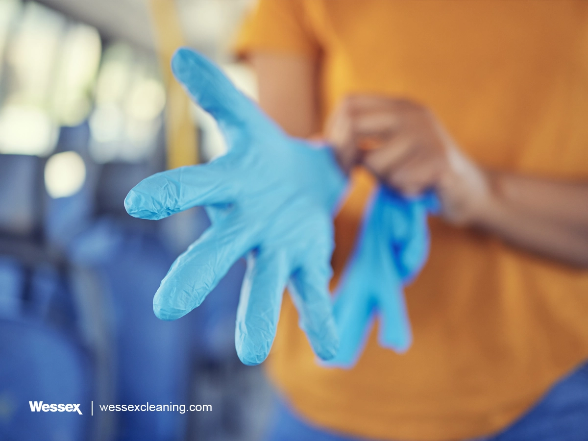 Hand wearing disposable glove for hygiene and safety in cleaning
