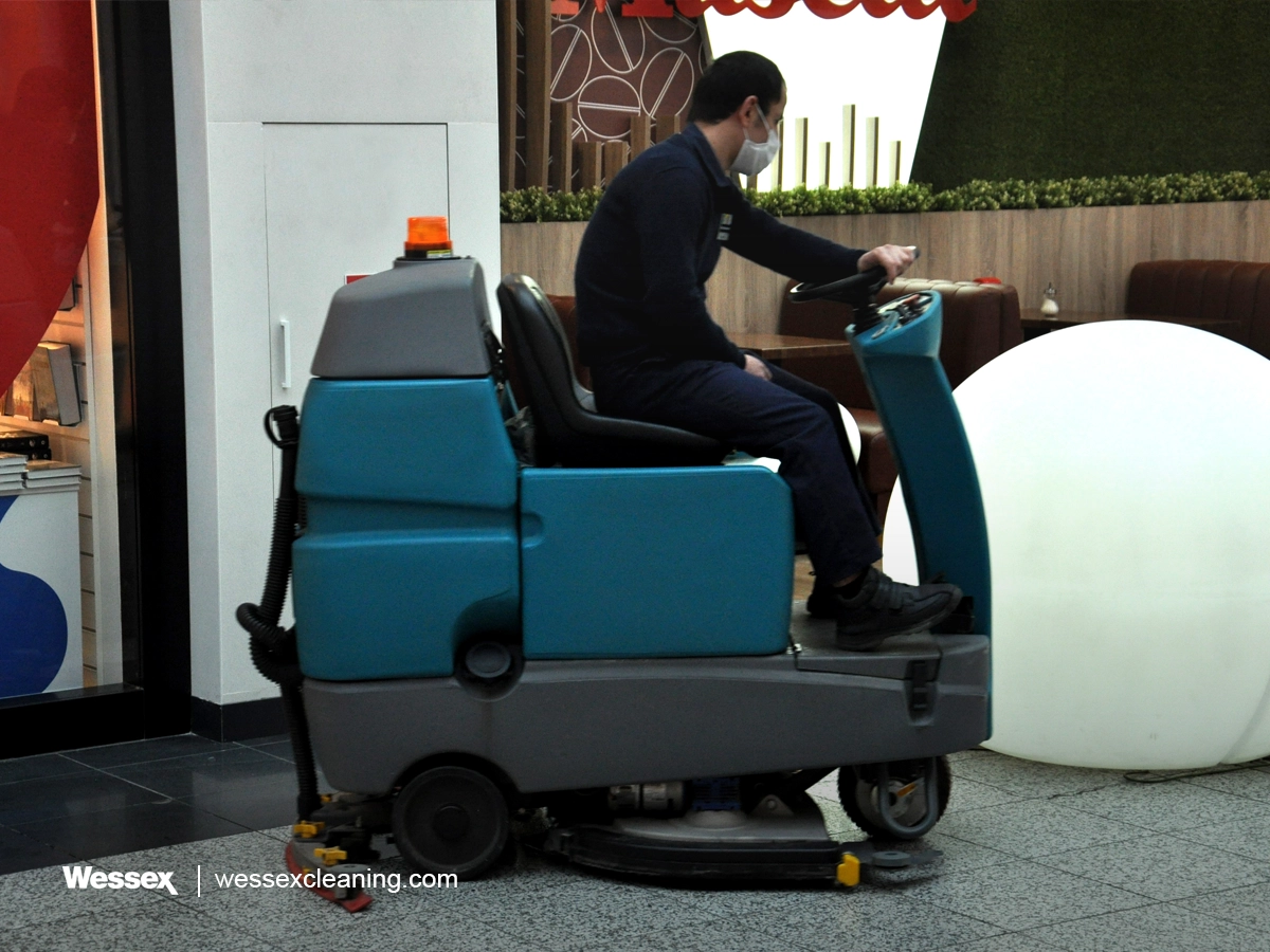 Man operating a scrubber dryer to clean floors in a shopping centre