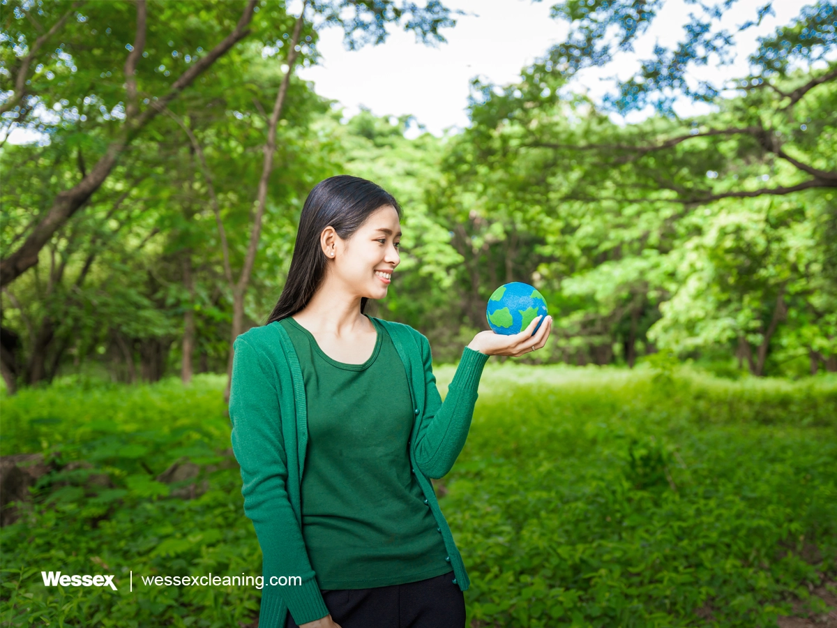 Forest conservationist holding a small globe in hands symbolising global responsibility