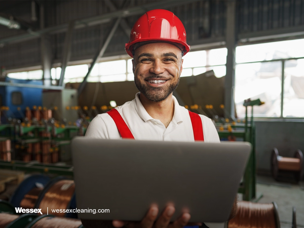 Industrial worker using laptop in cable production plant